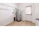 Bright laundry room featuring tile flooring, utility connections, and practical wire shelving for organized storage at 14706 Driftwater Dr, Winter Garden, FL 34787