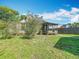 A view of the backyard showcasing a screened-in patio and a well-maintained lawn at 1511 New York Ave, St Cloud, FL 34769