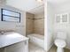 Bathroom features a tile bath/shower, a toilet and sink with storage at 1511 New York Ave, St Cloud, FL 34769