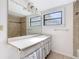 Bright bathroom featuring a large mirror, neutral tile, and a window at 1511 New York Ave, St Cloud, FL 34769