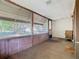 Enclosed front porch features wood paneling, multiple windows, and views of the neighborhood at 1511 New York Ave, St Cloud, FL 34769