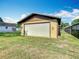 Exterior view of a detached garage with a white door and a well-maintained lawn at 1511 New York Ave, St Cloud, FL 34769