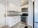 Modern kitchen with stainless steel appliances, gray floors and white cabinets at 1511 New York Ave, St Cloud, FL 34769