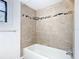 View of the shower with a neutral tile surround and a glass shelf at 1511 New York Ave, St Cloud, FL 34769