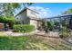 Exterior view of the home, screened-in pool area, patio and lush backyard landscaping at 162 Seville Chase Dr, Winter Springs, FL 32708