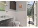 Stylish half bathroom with vanity, wood-paneled walls, and access to the screened-in lanai at 162 Seville Chase Dr, Winter Springs, FL 32708