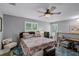 Relaxing bedroom with a dark studded bed, a ceiling fan, and bright windows at 162 Seville Chase Dr, Winter Springs, FL 32708