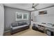 Functional bedroom with a gray sofa, built-in shelving, and a desk at 162 Seville Chase Dr, Winter Springs, FL 32708