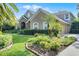 Charming front exterior featuring a stone archway, lush landscaping and a well manicured lawn at 162 Seville Chase Dr, Winter Springs, FL 32708
