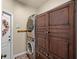 Convenient laundry room with stacked washer and dryer, storage cabinet, and access to outside at 162 Seville Chase Dr, Winter Springs, FL 32708