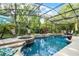 Screened pool area features a built-in jacuzzi surrounded by lush tropical landscaping at 162 Seville Chase Dr, Winter Springs, FL 32708