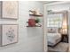 Stylishly decorated hallway featuring coastal decor, shelving, and a view into the primary bedroom at 1701 Canton Street, Orlando, FL 32803
