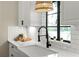 Kitchen sink features modern black hardware, bright window and stylish subway tile backsplash at 1701 Canton Street, Orlando, FL 32803
