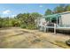 The home's backyard features an open parking area, back deck with green foliage, and covered porch at 2229 N 6Th St, Orlando, FL 32820