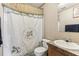 This bathroom features a vanity with sink, toilet, decorative shower curtain and neutral wall paneling at 2229 N 6Th St, Orlando, FL 32820