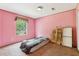 A pink bedroom with a bed, a window providing natural light and views of the outdoors at 2229 N 6Th St, Orlando, FL 32820