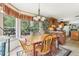 A cozy dining room with a large window, wooden table set, decorative chandelier and lush greenery views at 2229 N 6Th St, Orlando, FL 32820