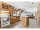 Open kitchen with a stove, sink, white appliances, ample counter space, and laminate flooring extending to the dining area at 2229 N 6Th St, Orlando, FL 32820