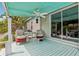 The covered porch features a ceiling fan, sliding glass door, and outdoor furniture with red cushions at 2229 N 6Th St, Orlando, FL 32820