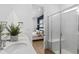 Bright bathroom with double vanity, quartz countertops, a walk-in shower, and view into the bedroom at 2291 Mossy Vine Ave, St Cloud, FL 34771