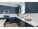 Modern kitchen featuring sleek blue cabinetry, white countertops, and stainless steel appliances at 2291 Mossy Vine Ave, St Cloud, FL 34771
