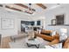 Spacious living room flows into the kitchen with bar seating, tan leather couches, and modern light fixture at 2291 Mossy Vine Ave, St Cloud, FL 34771