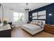 Main bedroom with accent wall, large window and tile flooring, and modern furniture with art at 2291 Mossy Vine Ave, St Cloud, FL 34771