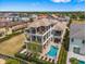 Expansive aerial view of a three-story home with multiple balconies and a backyard pool at 304 Muirfield Loop, Reunion, FL 34747