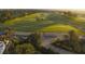 Expansive aerial of golf course showcasing lush green fairways, lined golf carts, and mature trees at 304 Muirfield Loop, Reunion, FL 34747