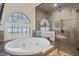 Stylish bathroom with a soaking tub, walk-in shower, and large windows for natural light at 304 Muirfield Loop, Reunion, FL 34747