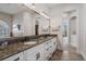 Elegant bathroom featuring a double vanity with granite countertops and an oversized mirror at 304 Muirfield Loop, Reunion, FL 34747