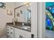 Bathroom featuring a white vanity with a decorative mirror and a view into a themed bedroom at 304 Muirfield Loop, Reunion, FL 34747