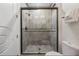 Bathroom glass shower featuring gray tile walls, and bronze fixtures with a rainfall shower head at 304 Muirfield Loop, Reunion, FL 34747