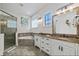 Bright bathroom with double vanity, granite countertops, and a separate glass-enclosed shower and tub at 304 Muirfield Loop, Reunion, FL 34747