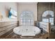 Relaxing bathroom with a large oval tub, a window with blinds, and a glass-enclosed shower at 304 Muirfield Loop, Reunion, FL 34747