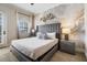 Comfortable bedroom with a tufted headboard bed, accent wall, and natural light from the windows at 304 Muirfield Loop, Reunion, FL 34747