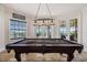 Billiards room with a pool table, tile floor, and natural light from windows and French doors at 304 Muirfield Loop, Reunion, FL 34747