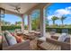 Inviting covered patio with plush seating, ceiling fan, and an outdoor view of the yard and nearby pool at 304 Muirfield Loop, Reunion, FL 34747