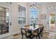 Bright dining room featuring a wood table, stylish chairs, and multiple windows overlooking the outdoor area at 304 Muirfield Loop, Reunion, FL 34747