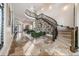 Grand foyer with curved staircase, stone floors, designer wallpaper, and elegant seating area at 304 Muirfield Loop, Reunion, FL 34747
