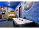 Themed game room featuring an air hockey table, arcade games, and vibrant wall art for Gathering fun at 304 Muirfield Loop, Reunion, FL 34747