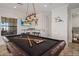 Stylish game room features a pool table, mounted television, bar seating, and unique decor for entertainment at 304 Muirfield Loop, Reunion, FL 34747