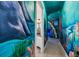 Hallway leading to an undersea-themed bedroom with whimsical murals and a view of the bathroom at 304 Muirfield Loop, Reunion, FL 34747