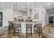 Open kitchen with stone floors, a large island with seating, granite countertops, and stainless steel appliances at 304 Muirfield Loop, Reunion, FL 34747