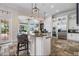 Open kitchen with stone floors, a large island with seating, granite countertops, and stainless steel appliances at 304 Muirfield Loop, Reunion, FL 34747