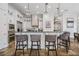 Spacious kitchen featuring stone floors, an island with bar seating, granite countertops, and stainless steel appliances at 304 Muirfield Loop, Reunion, FL 34747