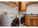Functional laundry room equipped with a washer, dryer, and built-in storage cabinets at 304 Muirfield Loop, Reunion, FL 34747