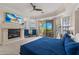 Comfortable primary bedroom with a stone fireplace, balcony access, and a ceiling fan at 304 Muirfield Loop, Reunion, FL 34747