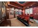 Luxurious home theater with plush seating, a projector screen, and themed decor for an immersive viewing experience at 304 Muirfield Loop, Reunion, FL 34747