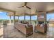 Covered outdoor patio with comfortable wicker furniture, ceiling fans, a fireplace, and scenic views at 304 Muirfield Loop, Reunion, FL 34747